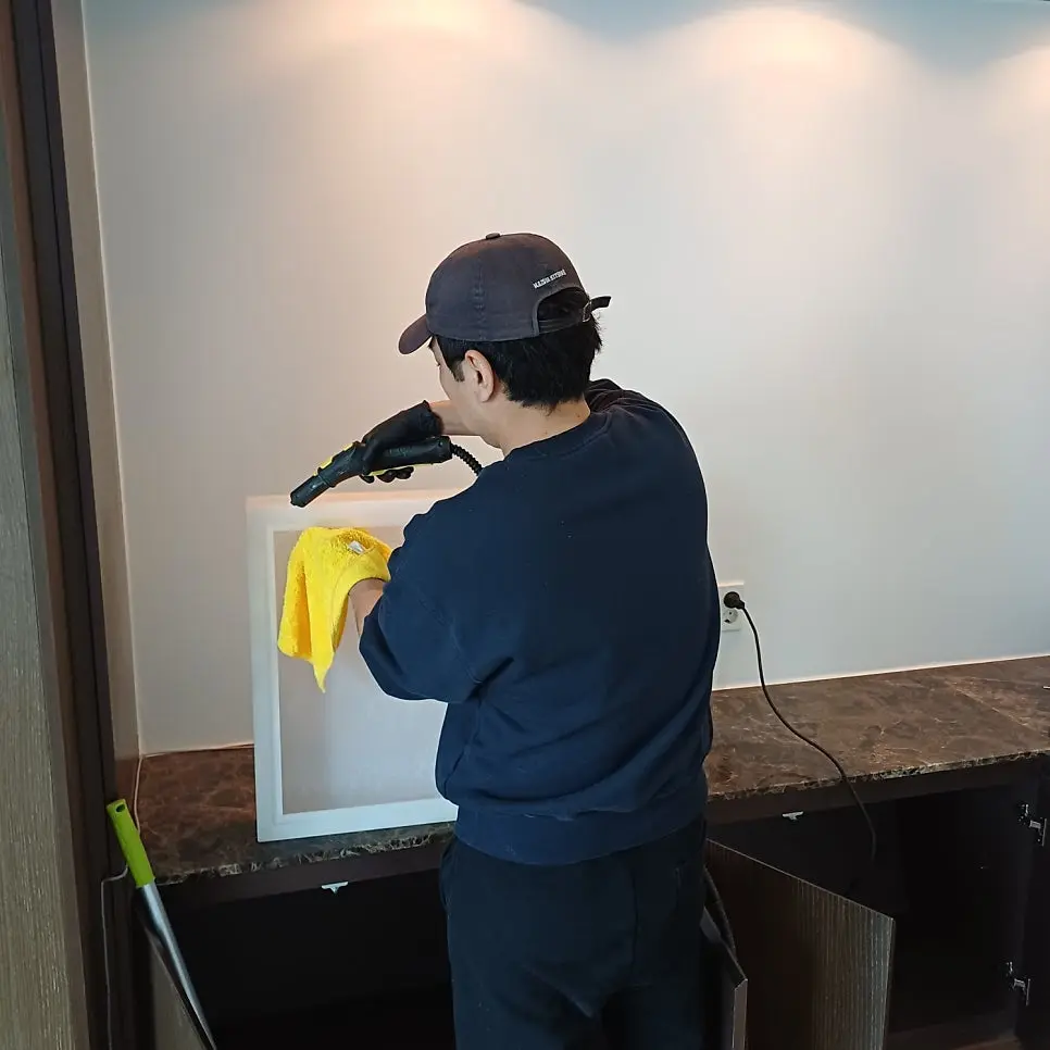 한 집에 붙어 구석을 닦고 있는 작업자