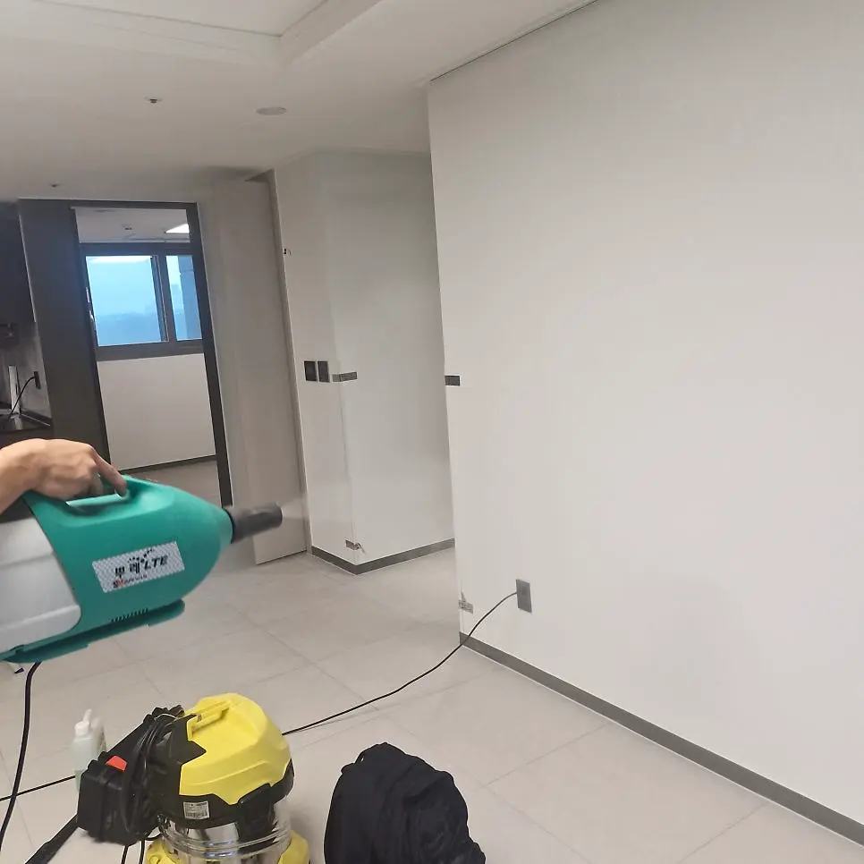 송풍기를 들고 빈 방을 말리는 작업자